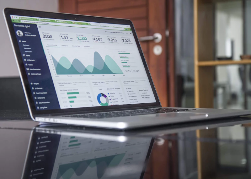 Laptop displaying business analytics and a cost-planning dashboard.
